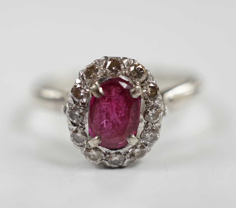 A white metal, synthetic? ruby and diamond set oval cluster ring, size P, gross weight 3.3 grams.